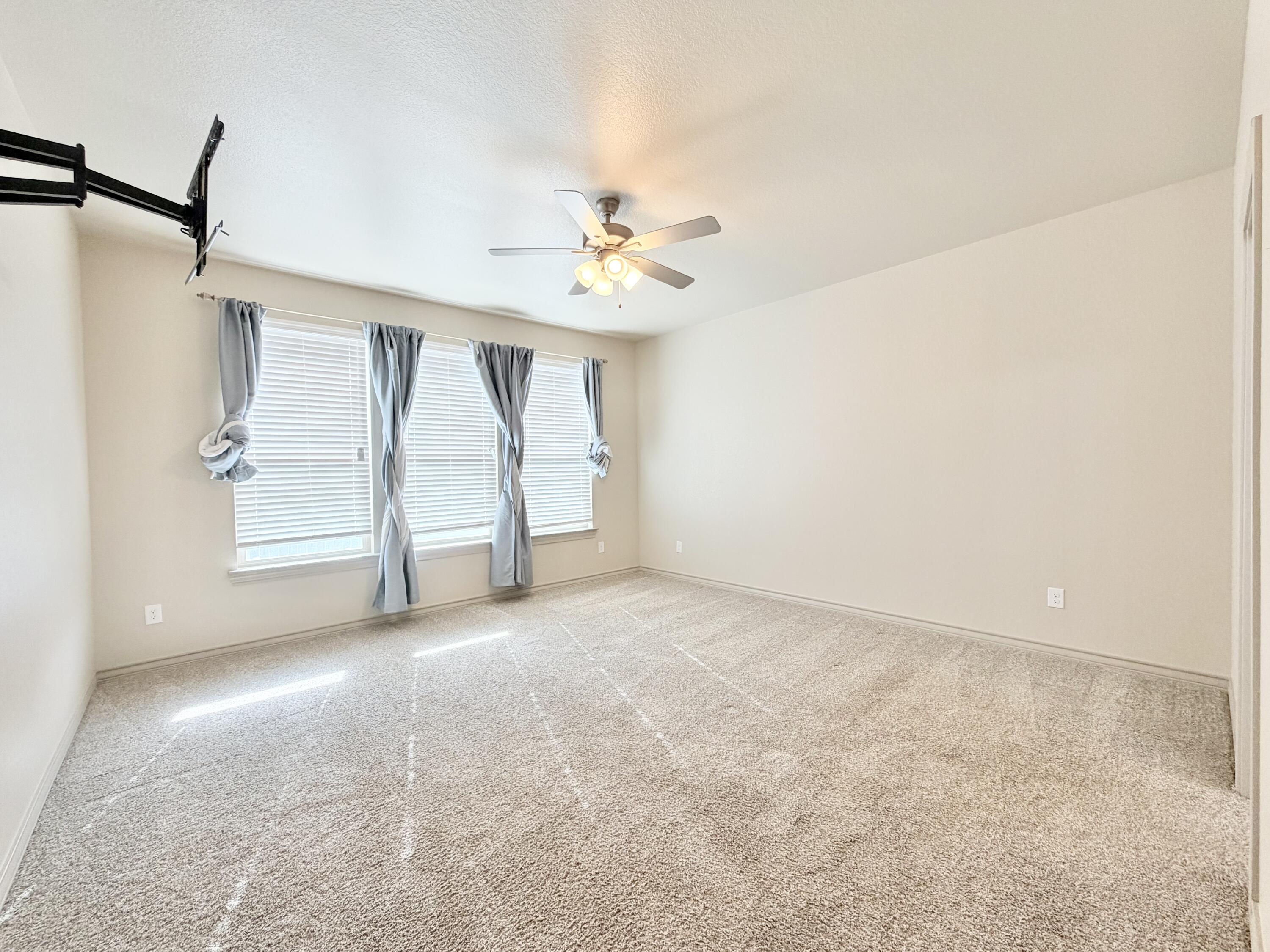 7611 61st Street Lubbock, TX 79407 - Photo 16 of 31 an empty room with windows and fan