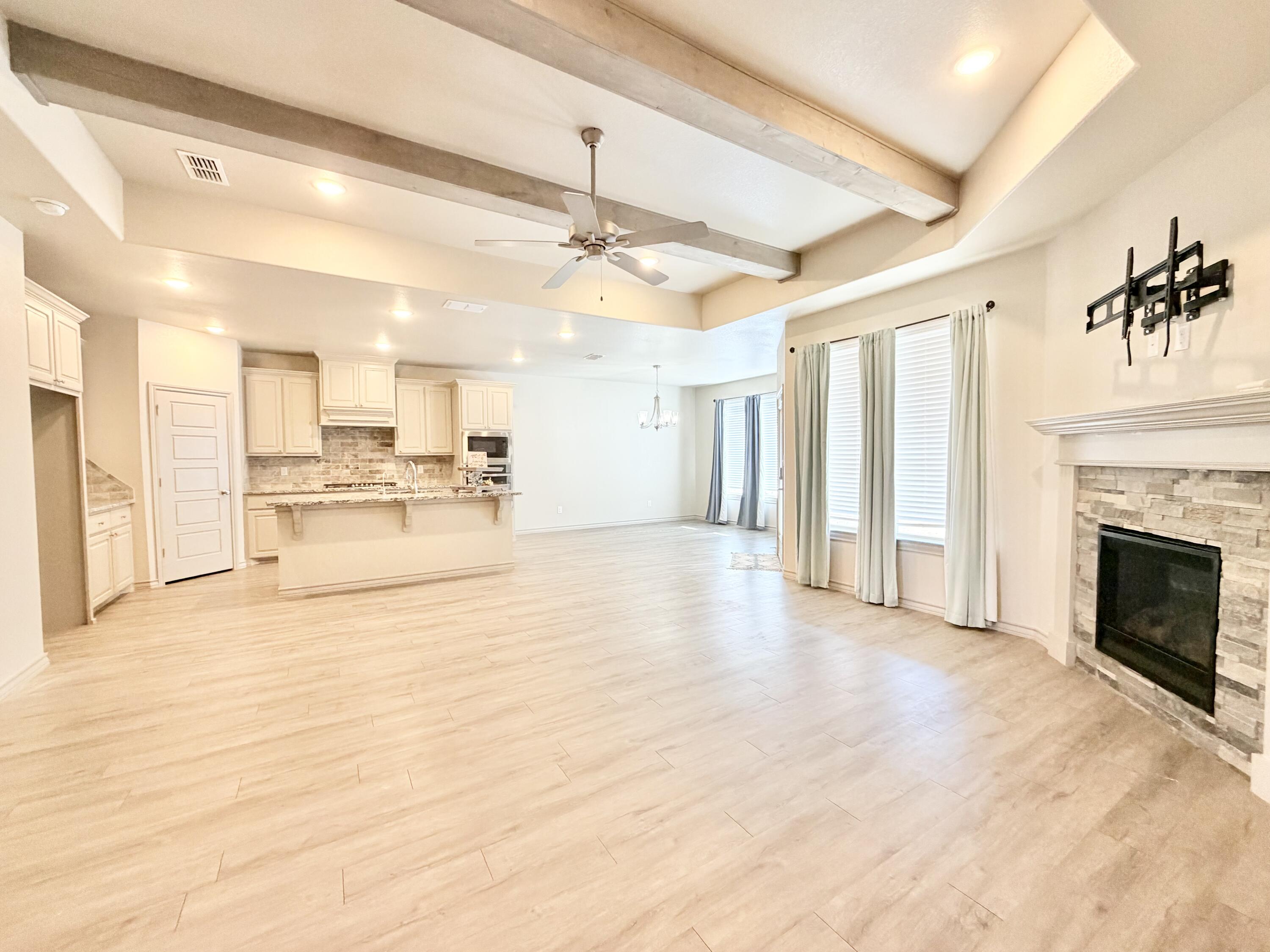 7611 61st Street Lubbock, TX 79407 - Photo 2 of 31 a view of a livingroom with kitchen and a fireplace