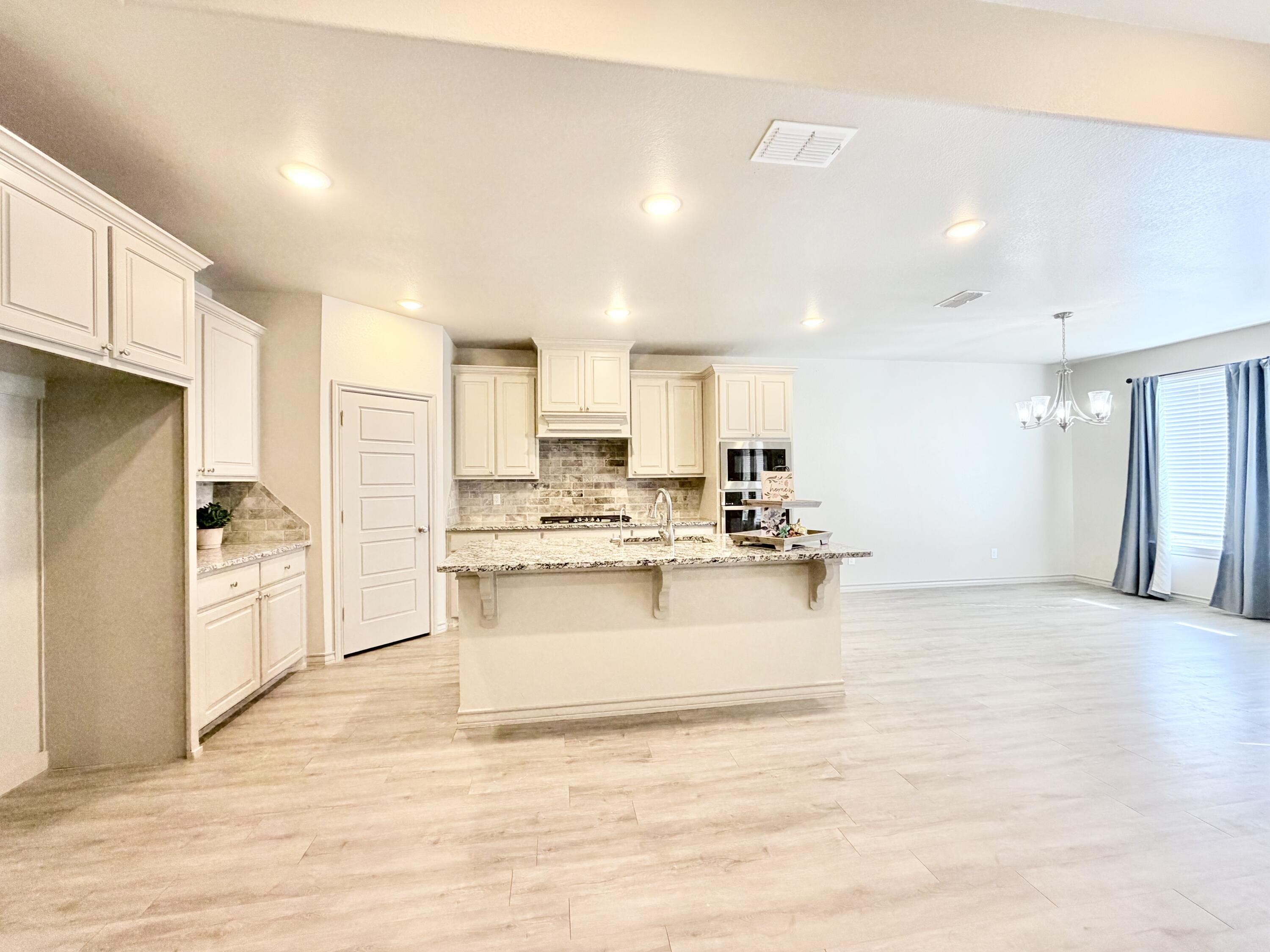 7611 61st Street Lubbock, TX 79407 - Photo 7 of 31 a view of kitchen with kitchen island a sink a center island stainless steel appliances and a cabinets
