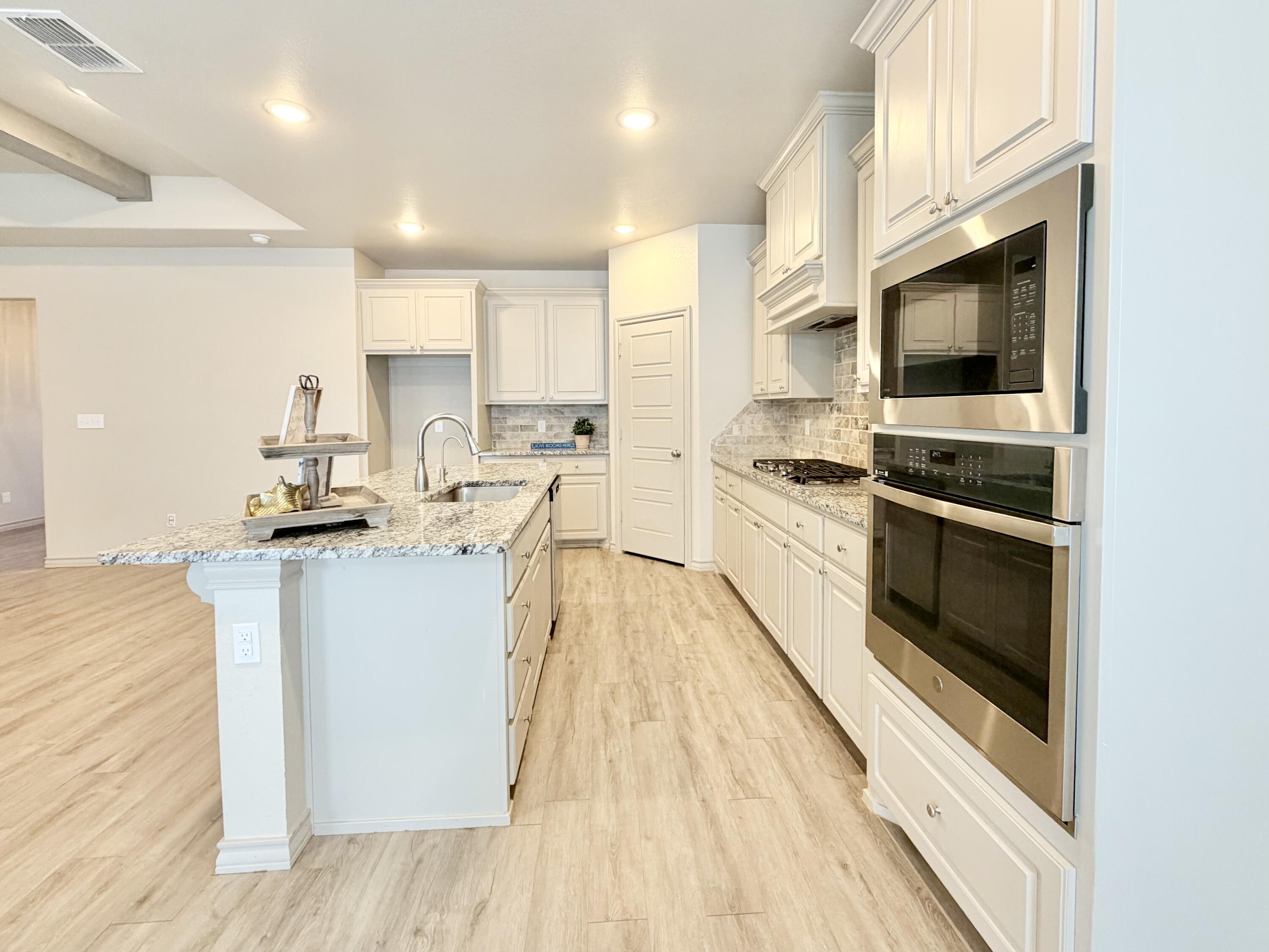 7611 61st Street Lubbock, TX 79407 - Photo 8 of 31 a kitchen with granite countertop a stove top oven and sink