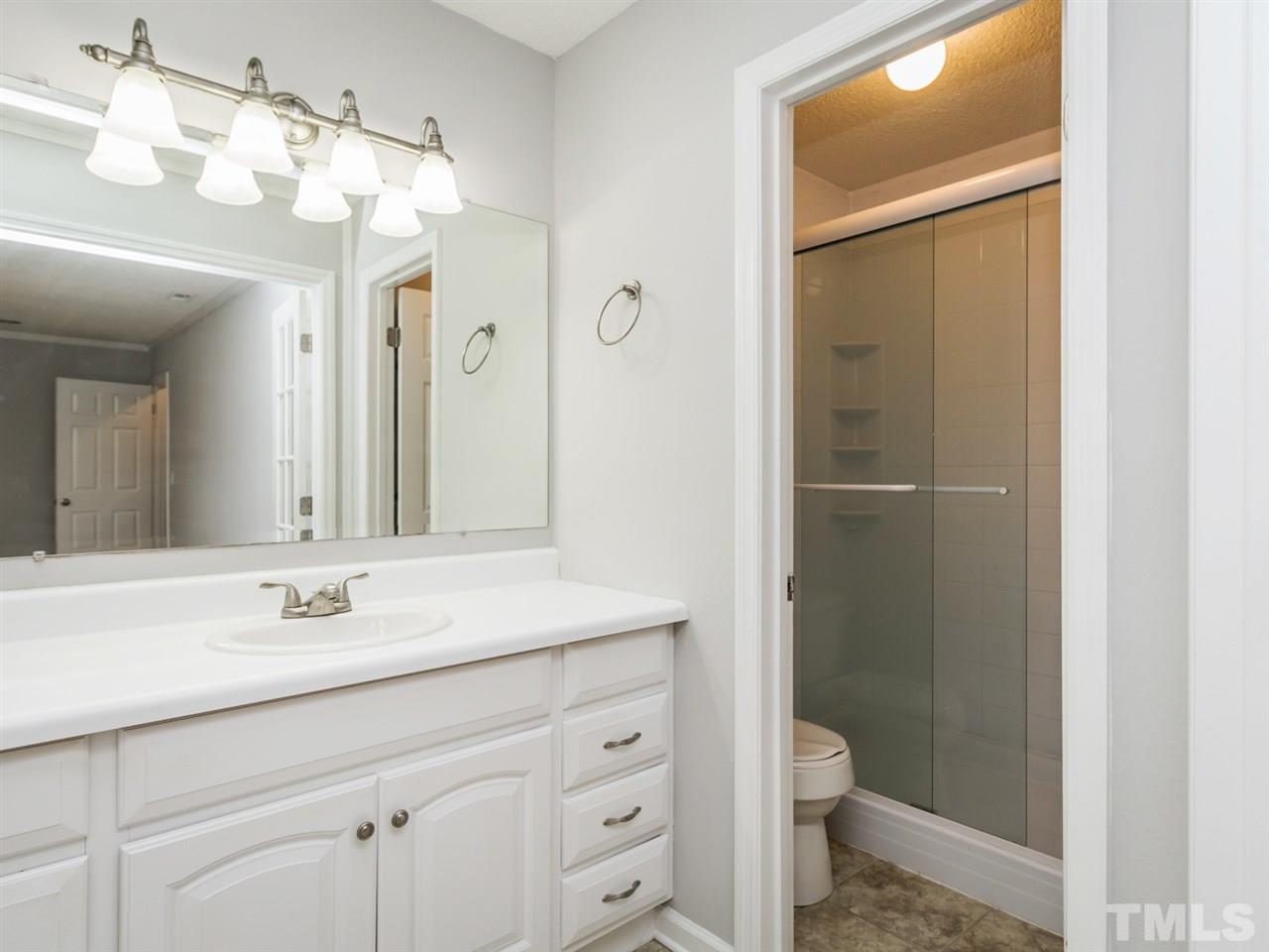 7706 Falcon Rest Circle, Unit N/A Raleigh, NC 27615 - Photo 14 of 19 a bathroom with a shower sink vanity and toilet