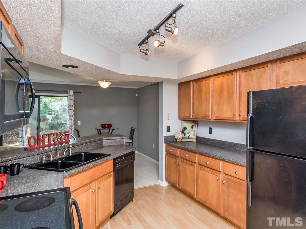 7706 Falcon Rest Circle, Unit N/A Raleigh, NC 27615 - Photo 7 of 19 a kitchen with stainless steel appliances granite countertop a sink stove and refrigerator