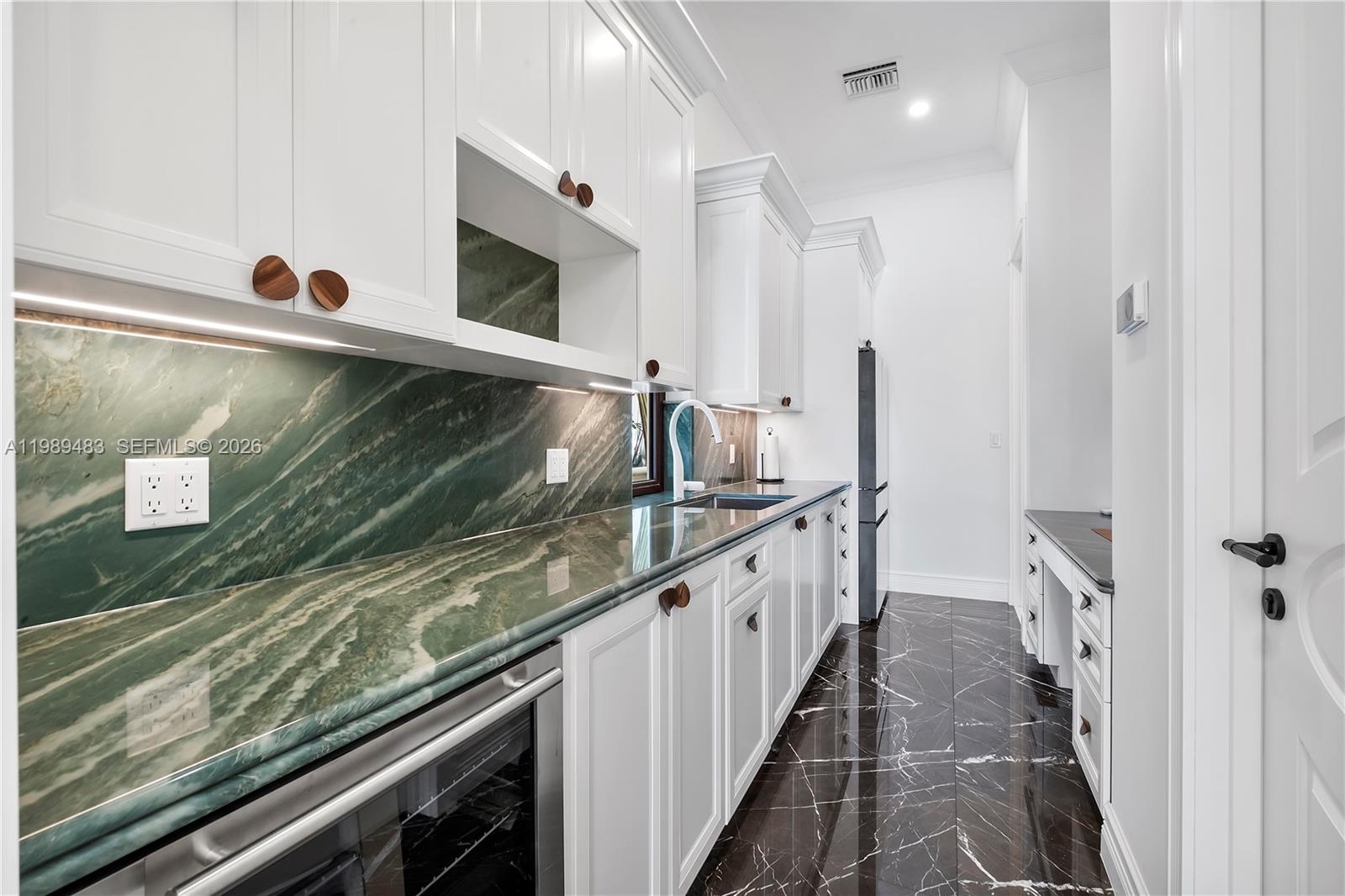 919 92nd Street Surfside, FL 33154 - Photo 27 of 74 a kitchen with granite countertop a sink and a stove top oven