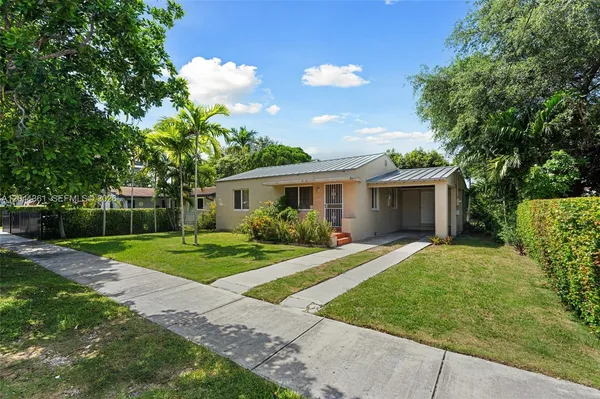 a front view of a house with a yard and trees