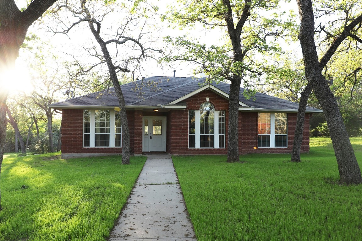 front view of a brick house with a yard