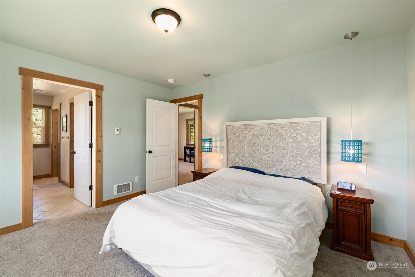 3956 Happy Valley Road Sequim, WA 98382 - Photo 29 of 40 a bedroom with a large bed and a chandelier