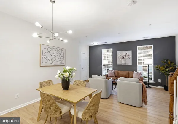 a view of a dining room and livingroom with furniture wooden floor a chandelier