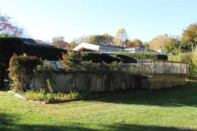 a view of a backyard with a large tree and wooden fence
