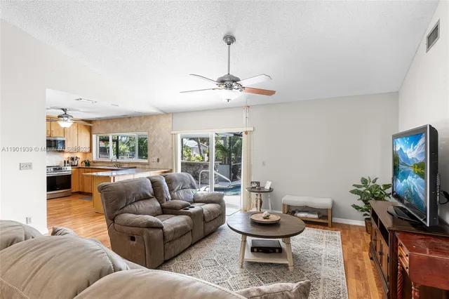 a living room with furniture a flat screen tv and a window
