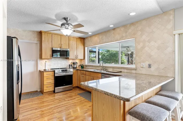 a kitchen with a center island appliances and cabinets