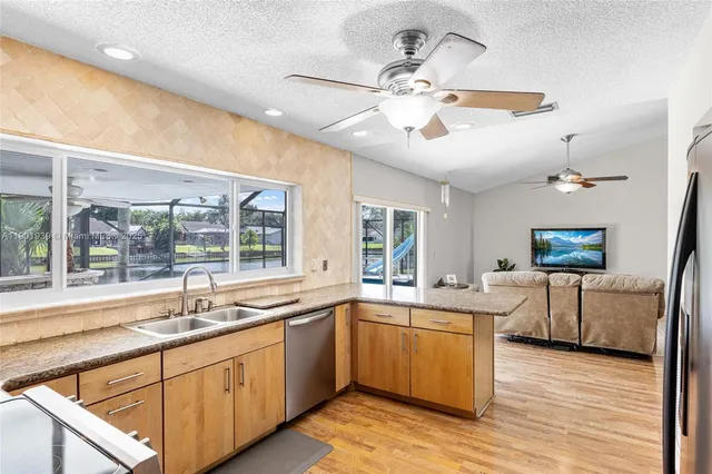a large kitchen with a large window a sink and cabinets