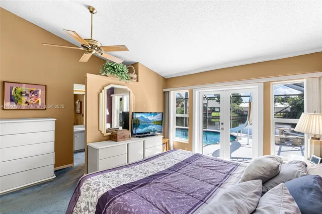 a bedroom with a bed a flat screen tv and a window