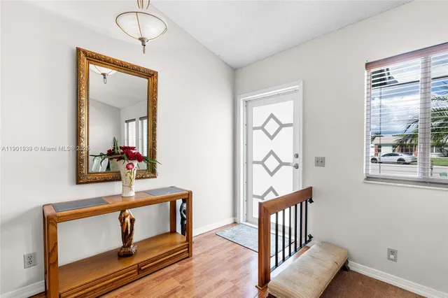 a view of a hallway with wooden floor and windows