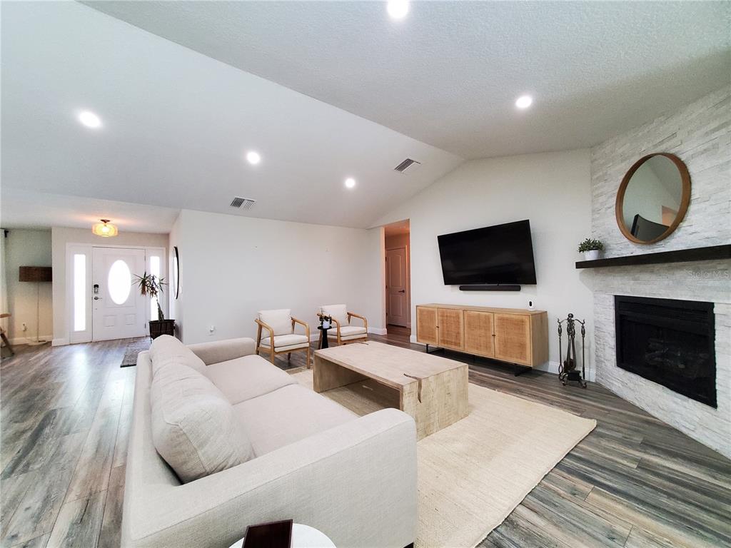 6522 Hidden Beach Circle Orlando, FL 32819 - Photo 21 of 65 a living room with furniture a flat screen tv and a fireplace