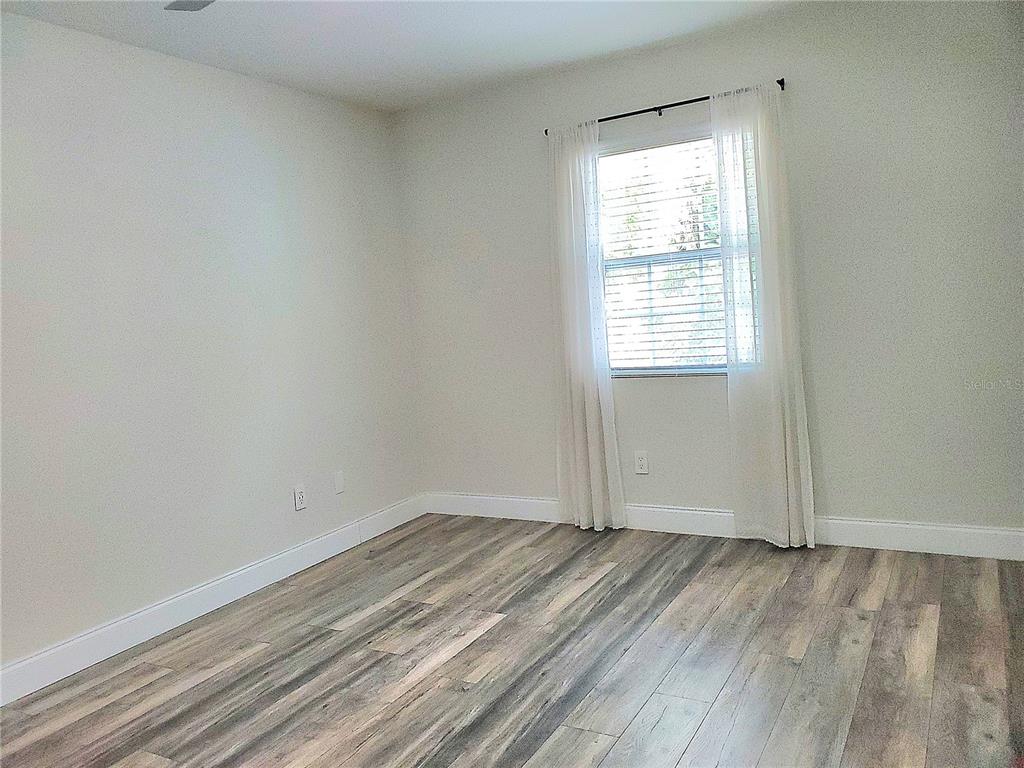 6522 Hidden Beach Circle Orlando, FL 32819 - Photo 43 of 65 an empty room with wooden floor and windows