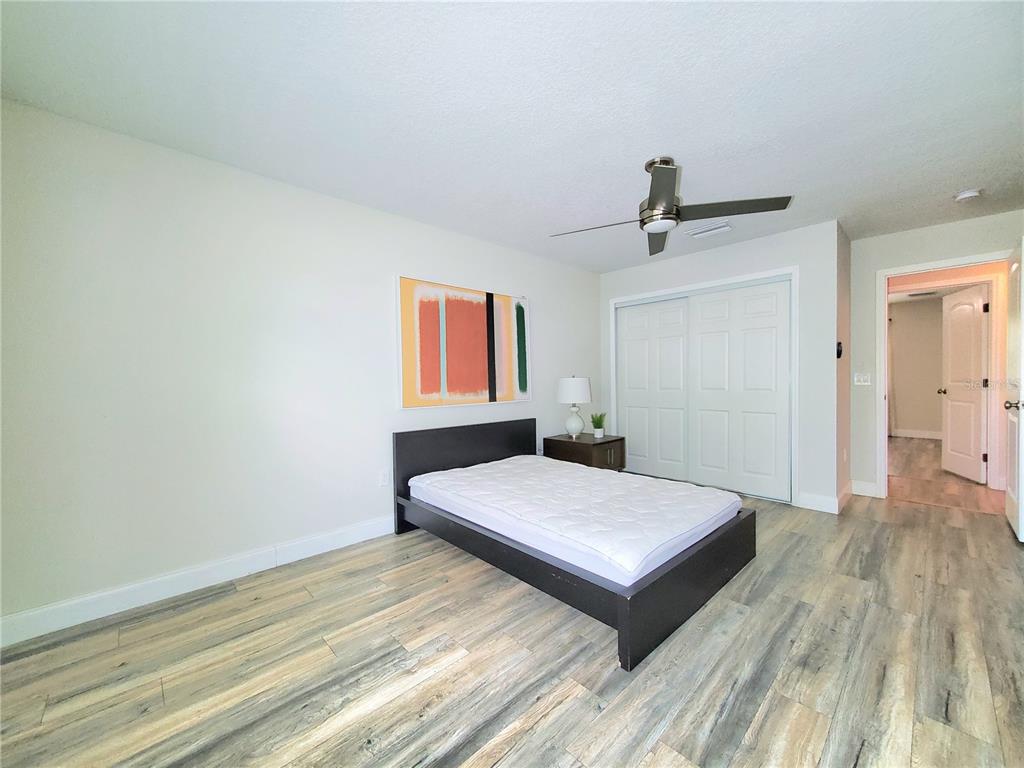 6522 Hidden Beach Circle Orlando, FL 32819 - Photo 48 of 65 a bedroom with a bed and wooden floor