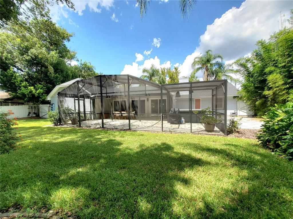 6522 Hidden Beach Circle Orlando, FL 32819 - Photo 63 of 65 a backyard of a house with table and chairs and potted plants