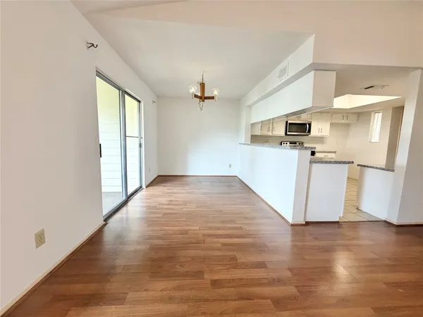 a view of a kitchen with a sink refrigerator and wooden floor