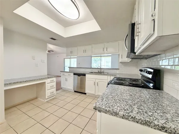 a kitchen with granite countertop white cabinets and white appliances