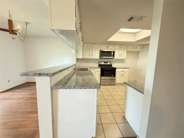 a kitchen with a sink a stove top oven a counter space and cabinets