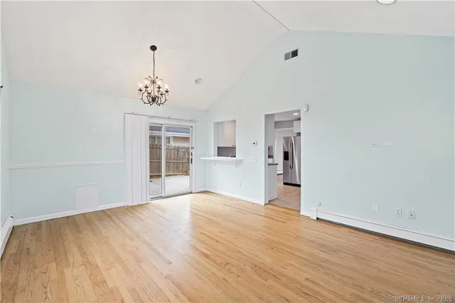 a view of an empty room with window and wooden floor