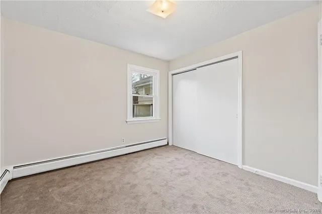 an empty room with windows and closet