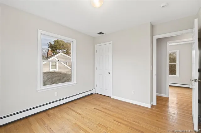 a view of an empty room with wooden floor