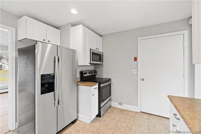 a kitchen with stainless steel appliances a refrigerator a sink and cabinets