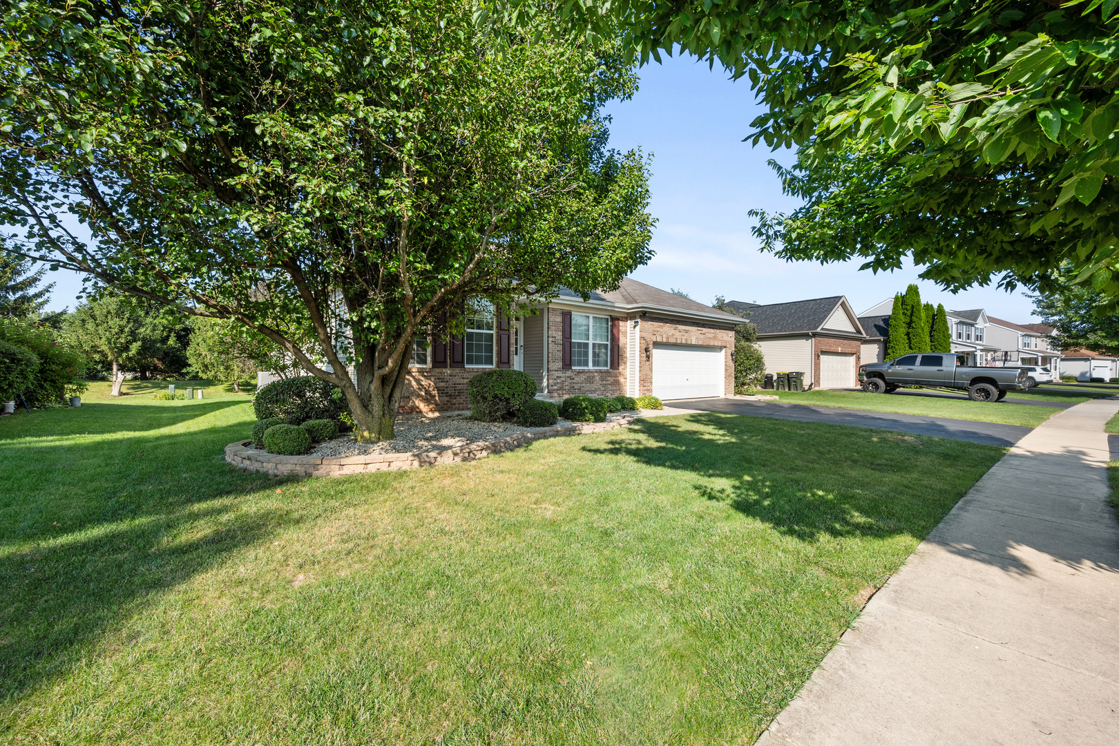 214 Stearn Drive Genoa, IL 60135 - Photo 3 of 24 a front view of a house with a yard and trees