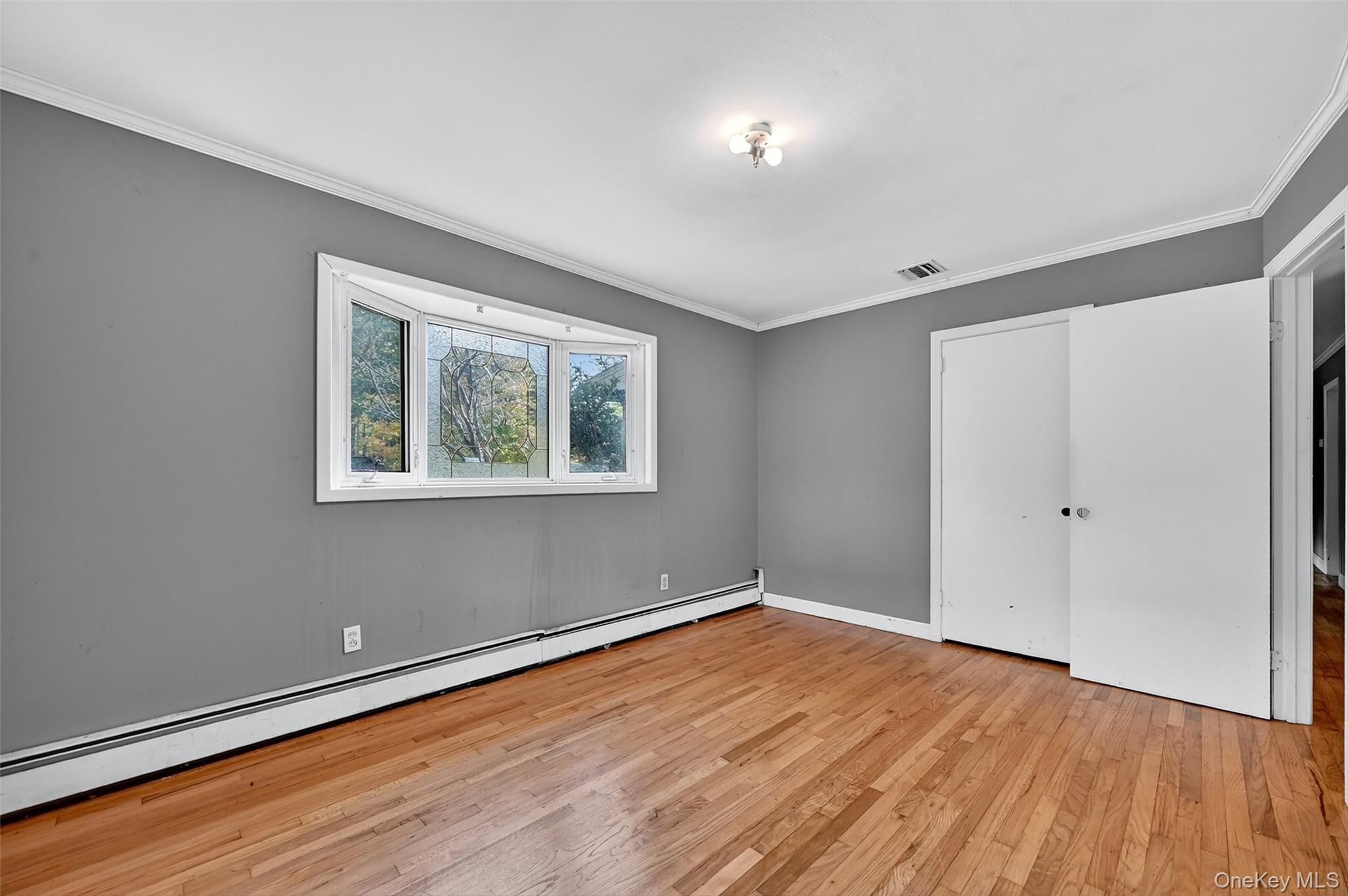 8 Haight Road Monroe, NY 10950 - Photo 25 of 40 Unfurnished bedroom featuring baseboard heating, light wood-style flooring, and crown molding