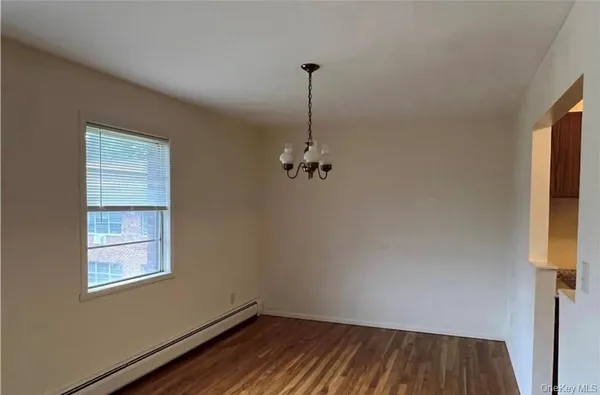 a view of a room with wooden floor cabinet and a window