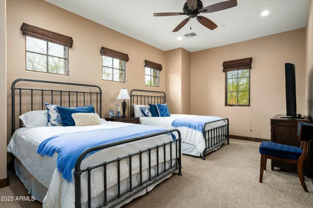 a bedroom with two beds and a chandelier