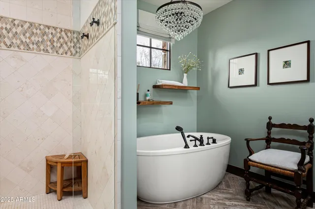 a white bath tub sitting next to a blue chair