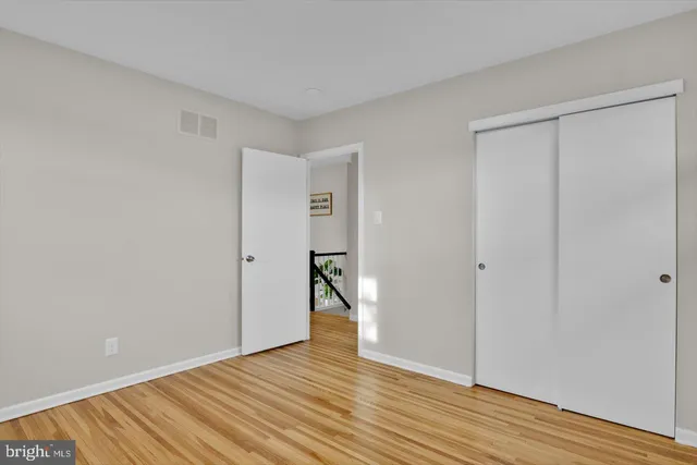 a view of a hallway with wooden floor and a potted plant