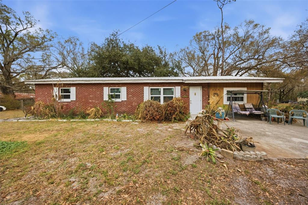 a front view of house with yard and trees around