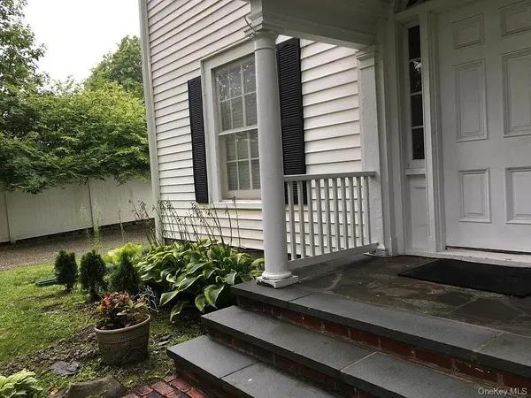a view of a backyard with chair and potted plants