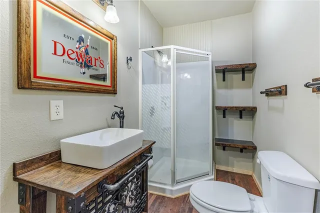 a bathroom with a sink a toilet and shower