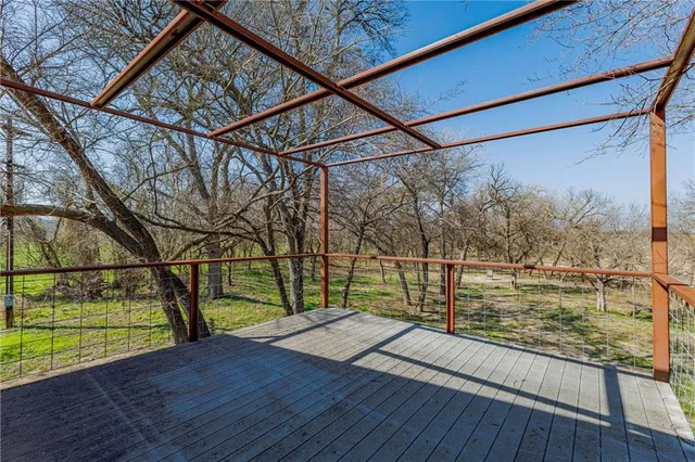a view of a balcony with wooden floor and fence