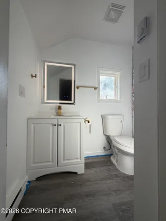 a bathroom with a toilet a sink and mirror