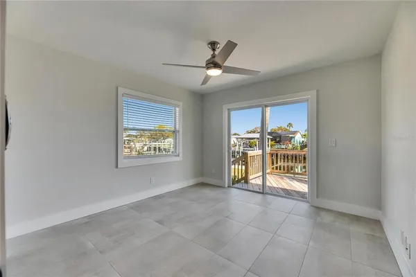 a view of an empty room with chandelier fan and fire place