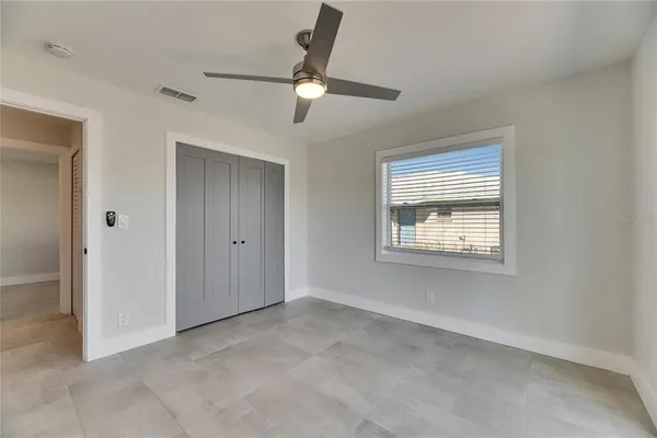 an empty room with a ceiling fan and closet