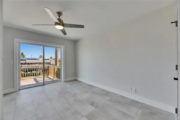 a view of a room with a ceiling fan and window