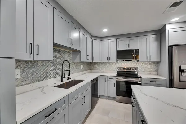 a kitchen with a sink a stove a microwave and cabinets