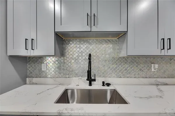 a kitchen with stainless steel appliances granite countertop a sink and a white cabinets