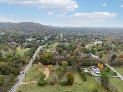 an aerial view of residential houses with outdoor space and trees