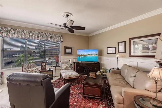 a living room with furniture a ceiling fan and a flat screen tv