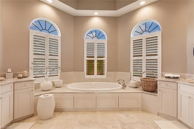 a bathroom with double vanity sink a mirror and a bathtub