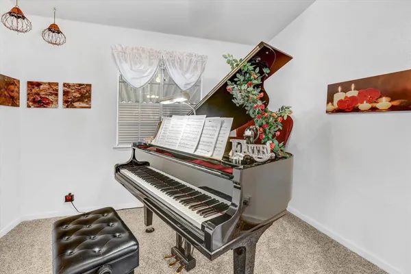 a living room with furniture and a piano