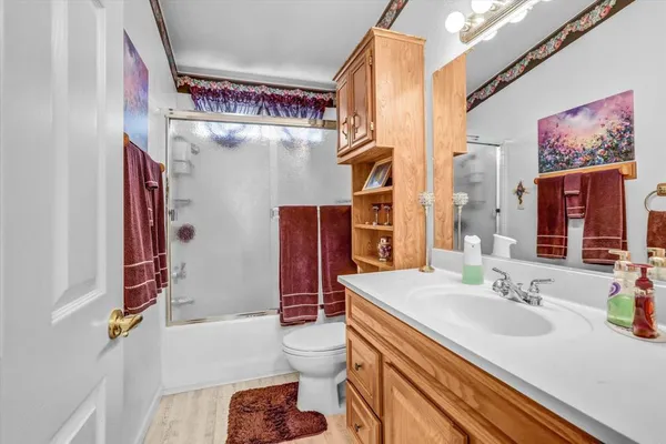 a bathroom with a sink a toilet and shower