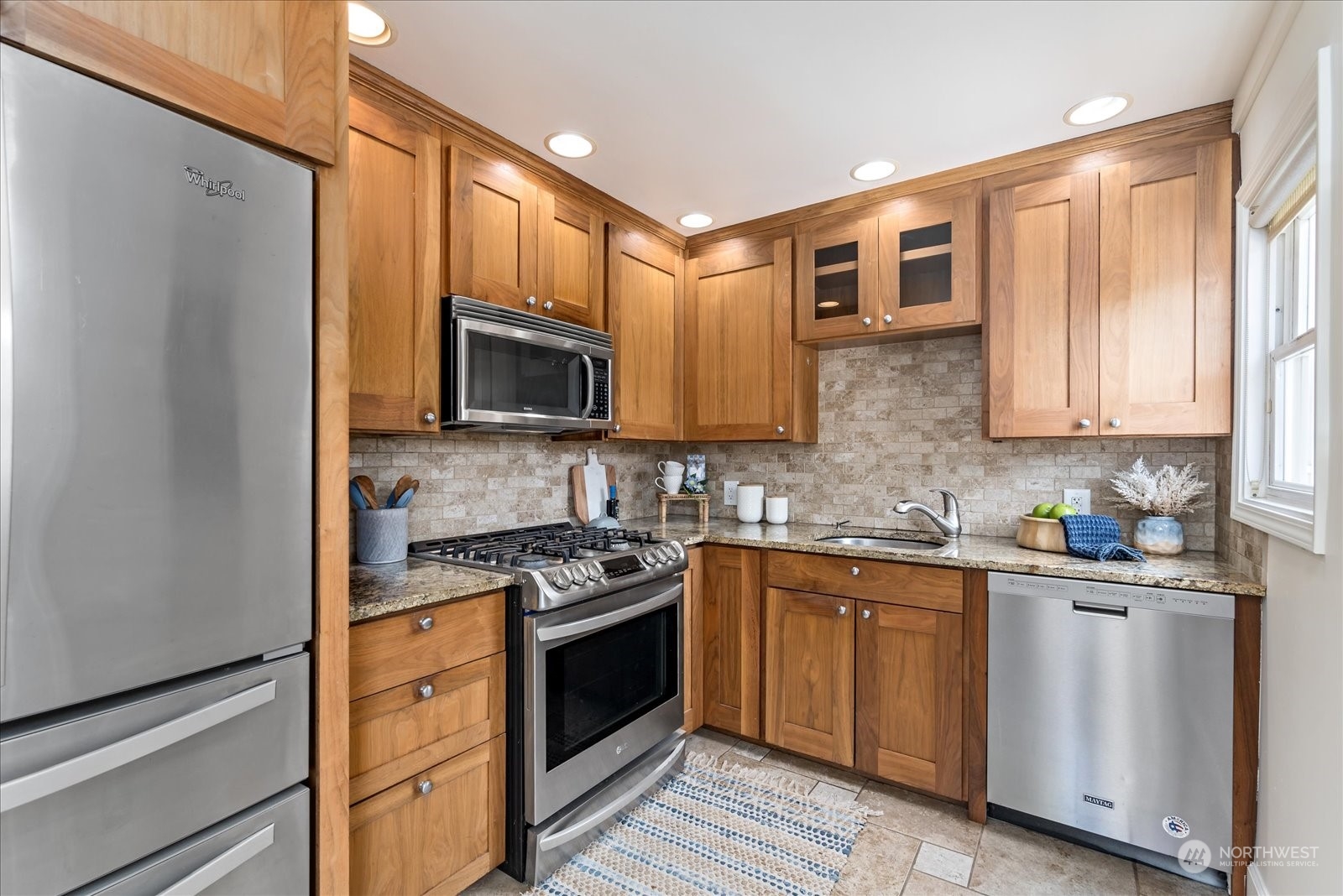 4839 50th Avenue Southwest Seattle, WA 98116 - Photo 10 of 31 a kitchen with stainless steel appliances granite countertop white cabinets a stove top oven a sink and dishwasher